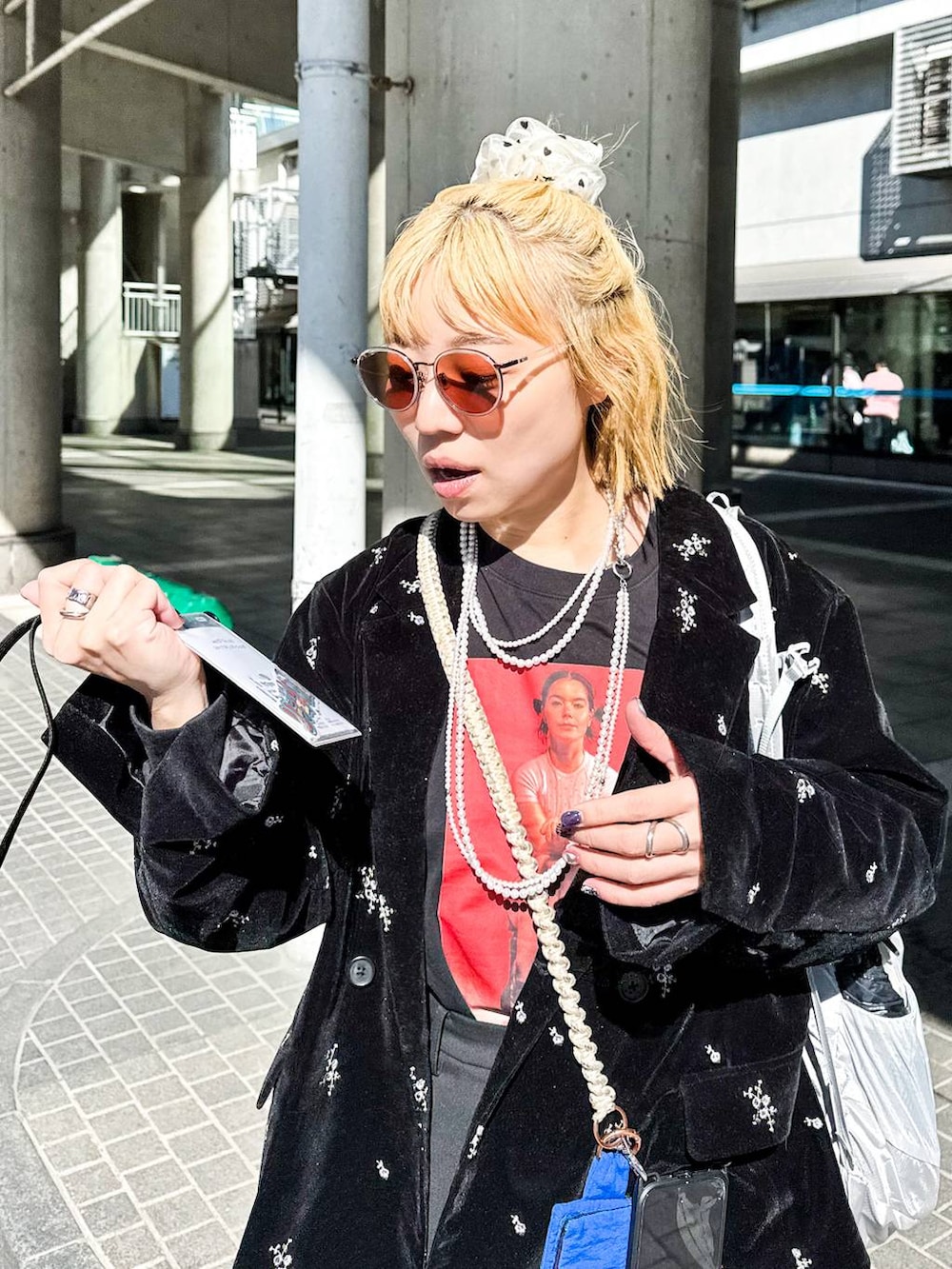 ブラック系のテーラードジャケット、ブラック系のスラックス、ベージュ系のシュシュを着用したレディースの冬コーディネートの4枚目の写真