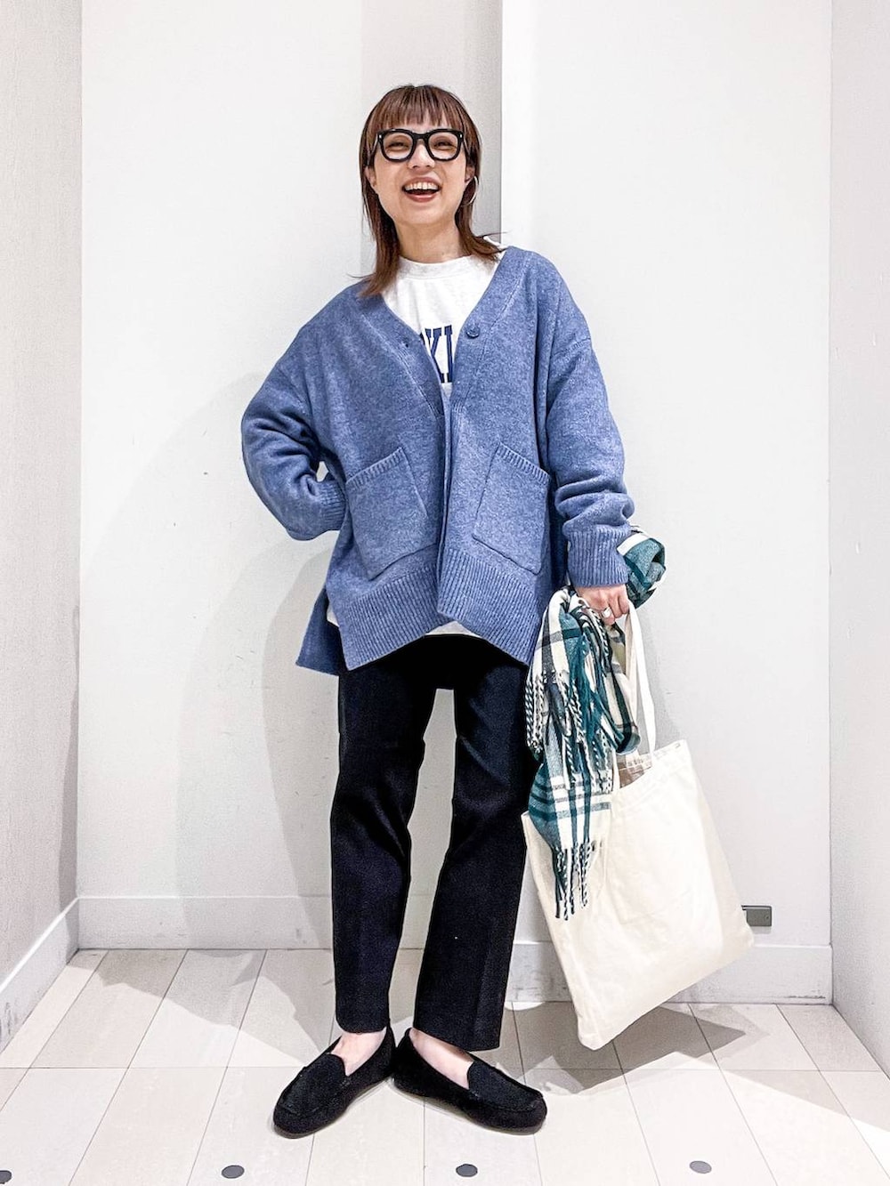 ホワイト系のトートバッグ、グレー系のTシャツ/カットソー、ブルー系のカーディガン/ボレロを着用したレディースの秋コーディネートの2枚目の写真