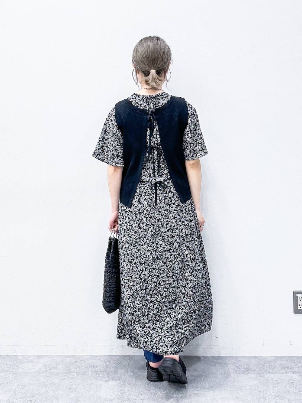 ブルー系のスラックス、ブラック系のサンダル、ブラック系のベストを着用したレディースの春コーディネートの4枚目の写真