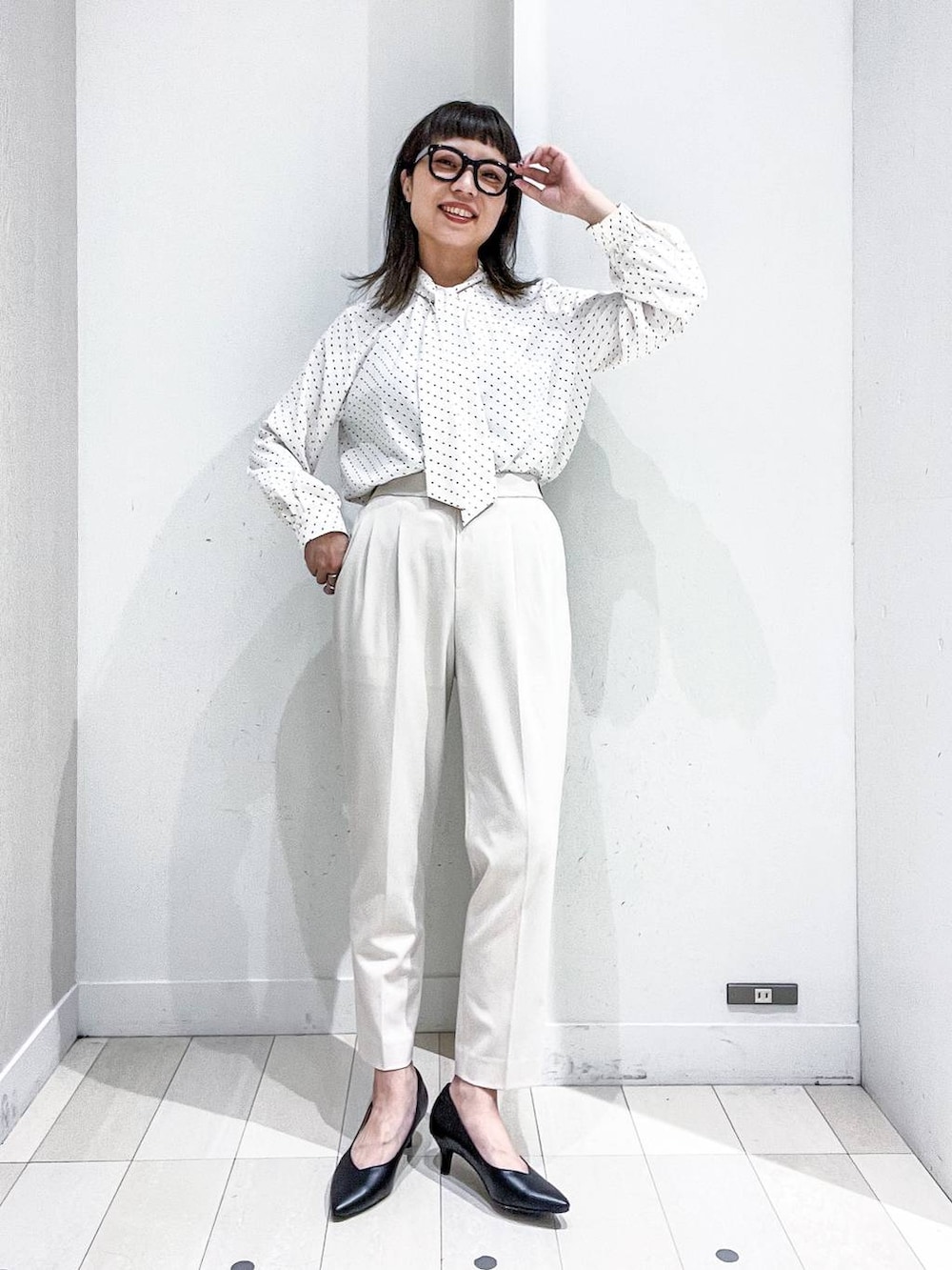 ブラック系のパンプス、ホワイト系のスーツジャケット、ホワイト系のシャツ/ブラウスを着用したレディースの冬コーディネートの6枚目の写真