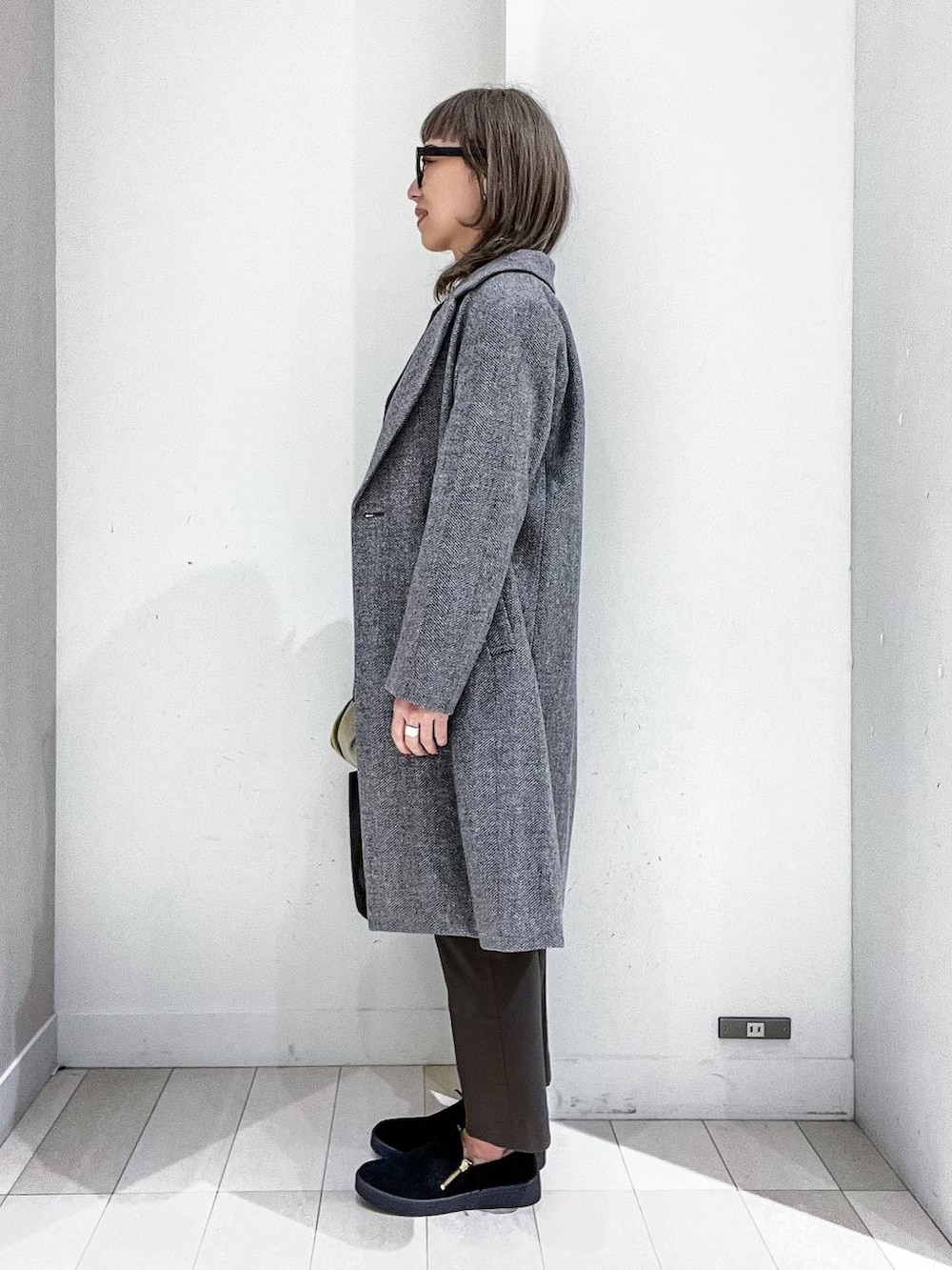 グレー系のチェスターコート、その他のTシャツ/カットソー、ブラック系のニット/セーターを着用したレディースの冬コーディネートの3枚目の写真