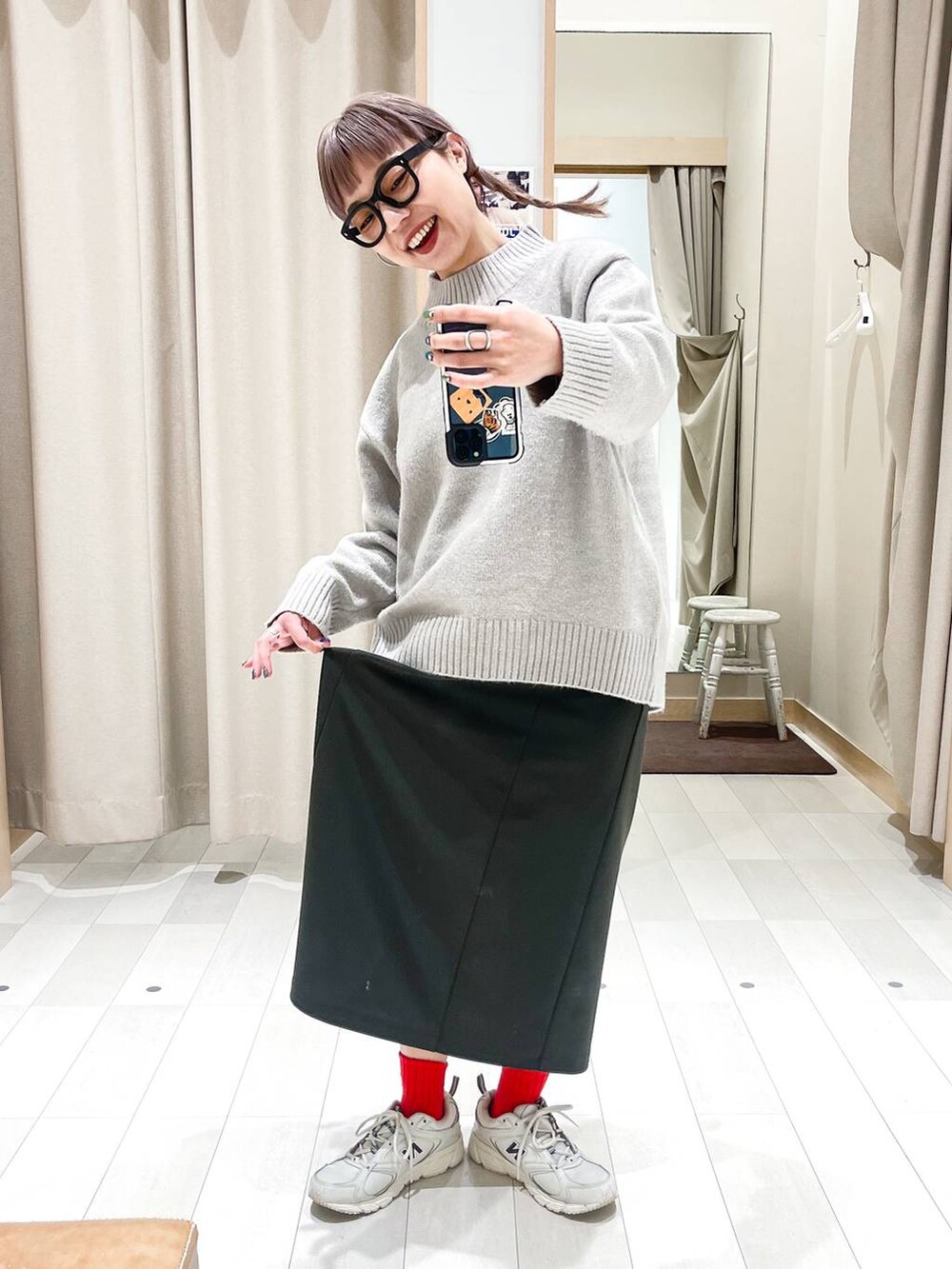 グリーン系のワンピース、ベージュ系のニット/セーター、ブラック系のメガネを着用したレディースの冬コーディネートの5枚目の写真