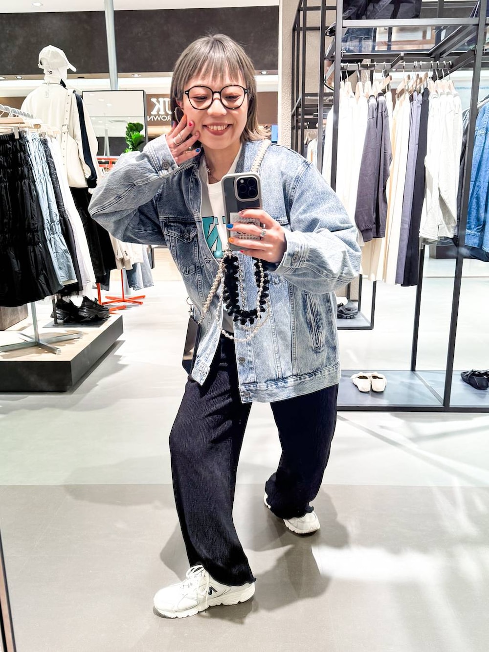 ホワイト系のスウェット、ブルー系のデニムジャケット、ブラック系のその他パンツを着用したレディースの春コーディネートの2枚目の写真