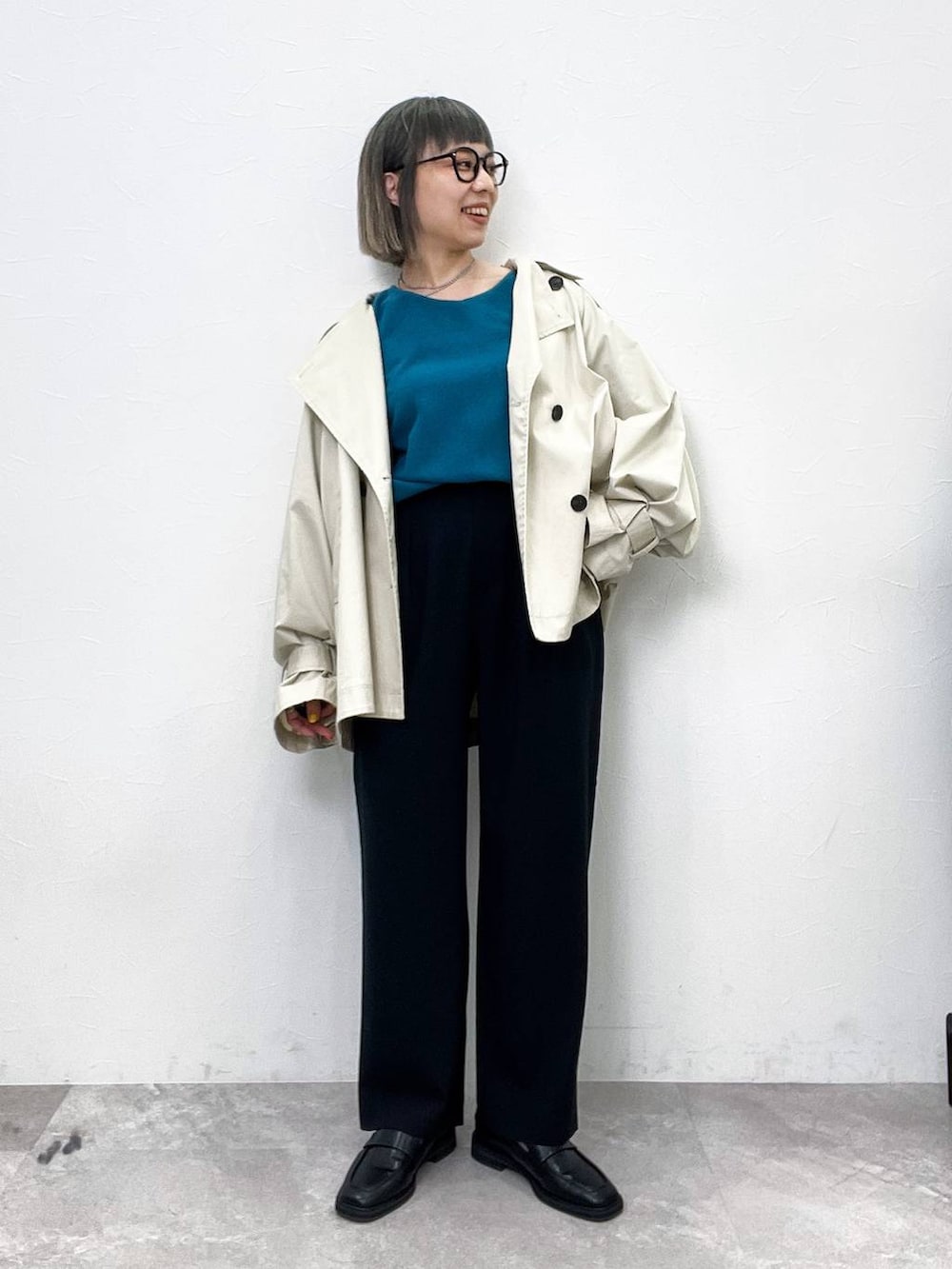 ブラック系のローファー、ベージュ系のトレンチコート、ブラック系のその他パンツを着用したレディースの春コーディネートの2枚目の写真