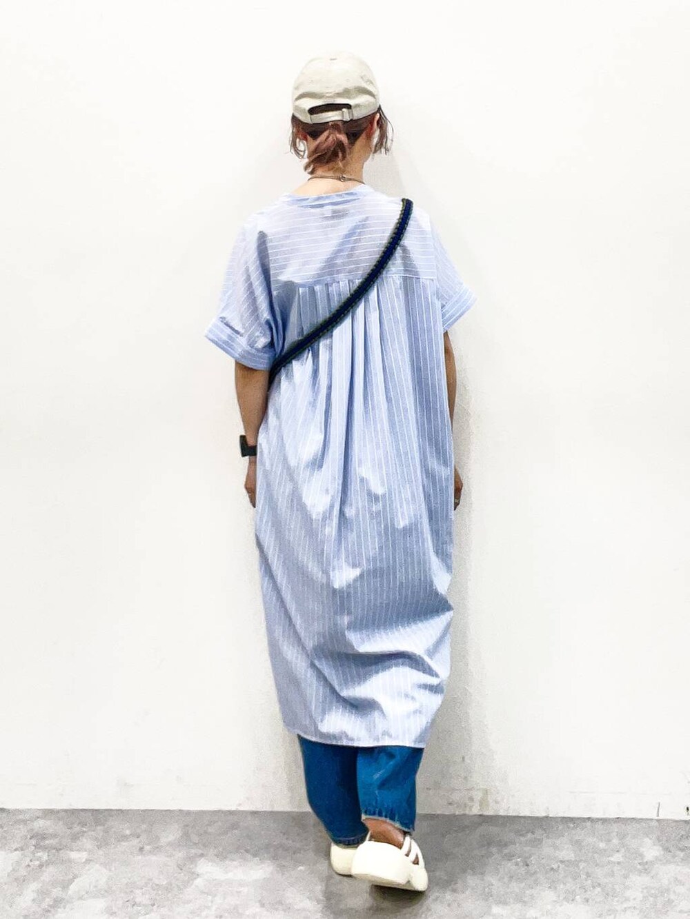 ホワイト系のサンダル、オレンジ系のショルダーバッグ、ブルー系のデニムパンツを着用したレディースの夏コーディネートの4枚目の写真