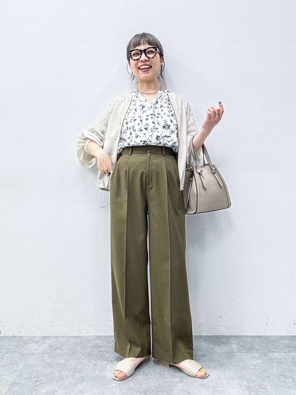 ベージュ系のショルダーバッグ、ベージュ系のサンダル、ホワイト系のシャツ/ブラウスを着用したレディースの春コーディネートの2枚目の写真