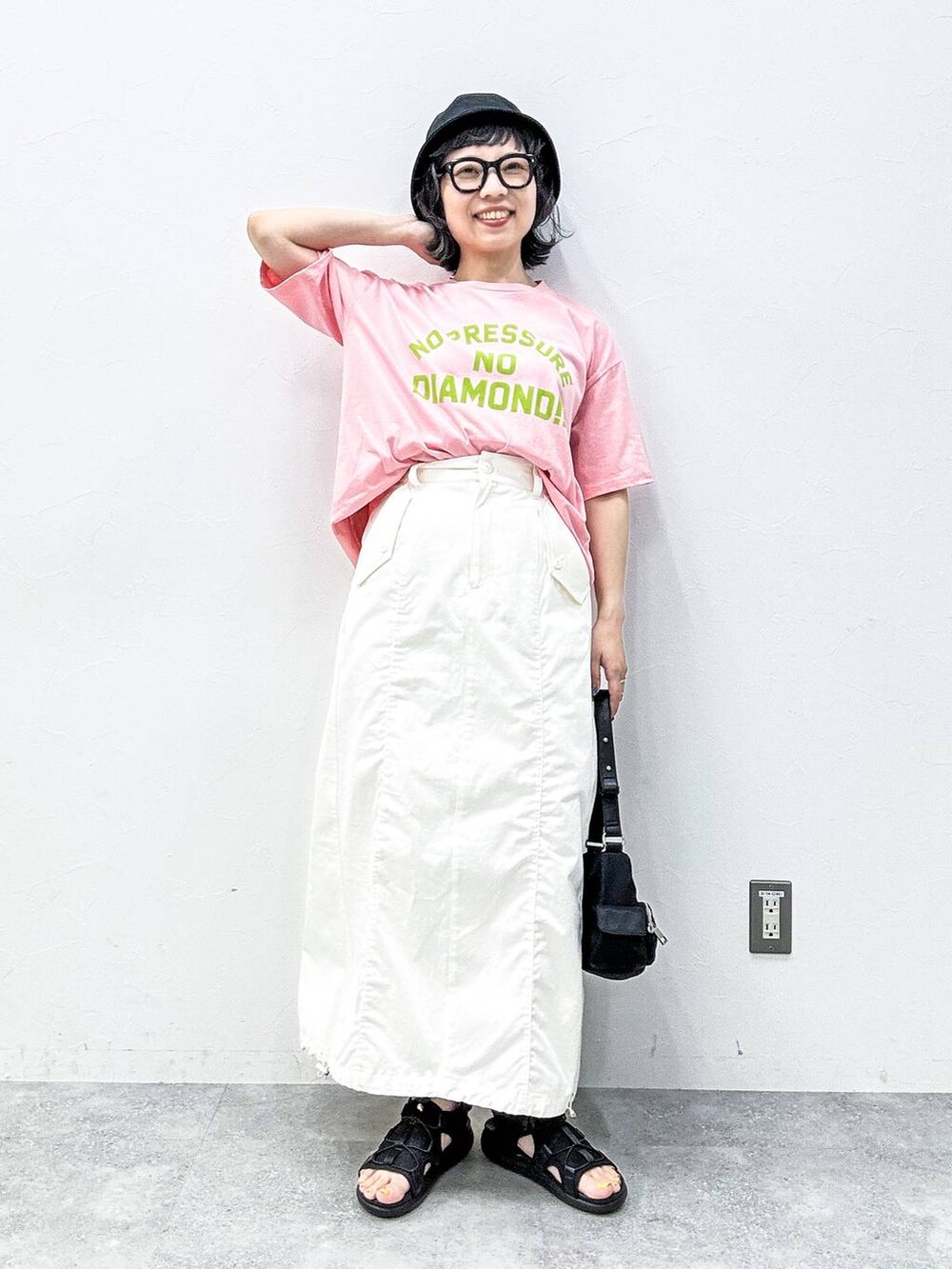 ホワイト系のスカート、ブラック系のサンダル、ピンク系のTシャツ/カットソーを着用したレディースの春コーディネートの2枚目の写真