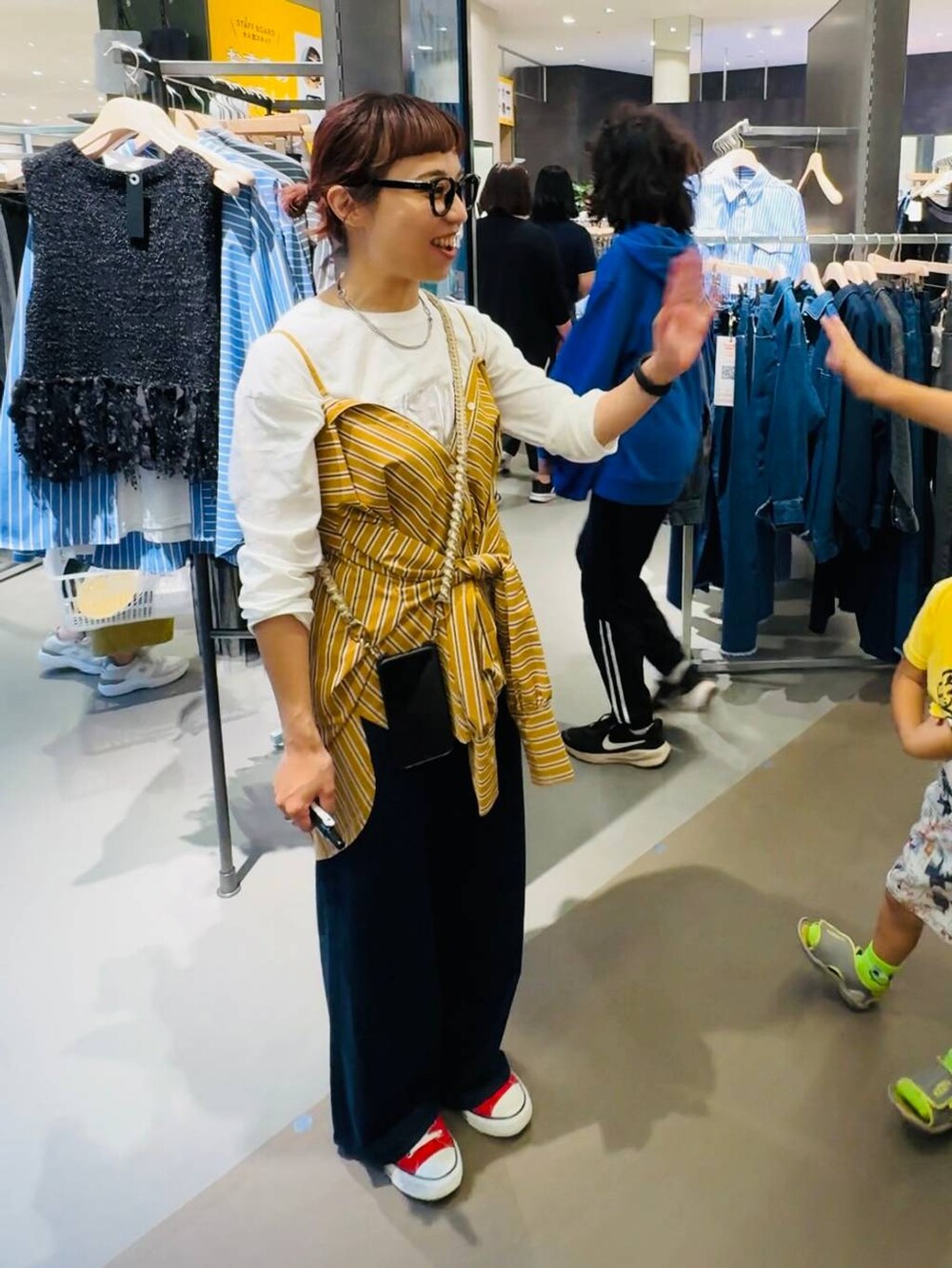 イエロー系のシャツ/ブラウス、ブラック系のバックパック/リュック、ホワイト系のTシャツ/カットソーを着用したレディースの秋コーディネートの3枚目の写真