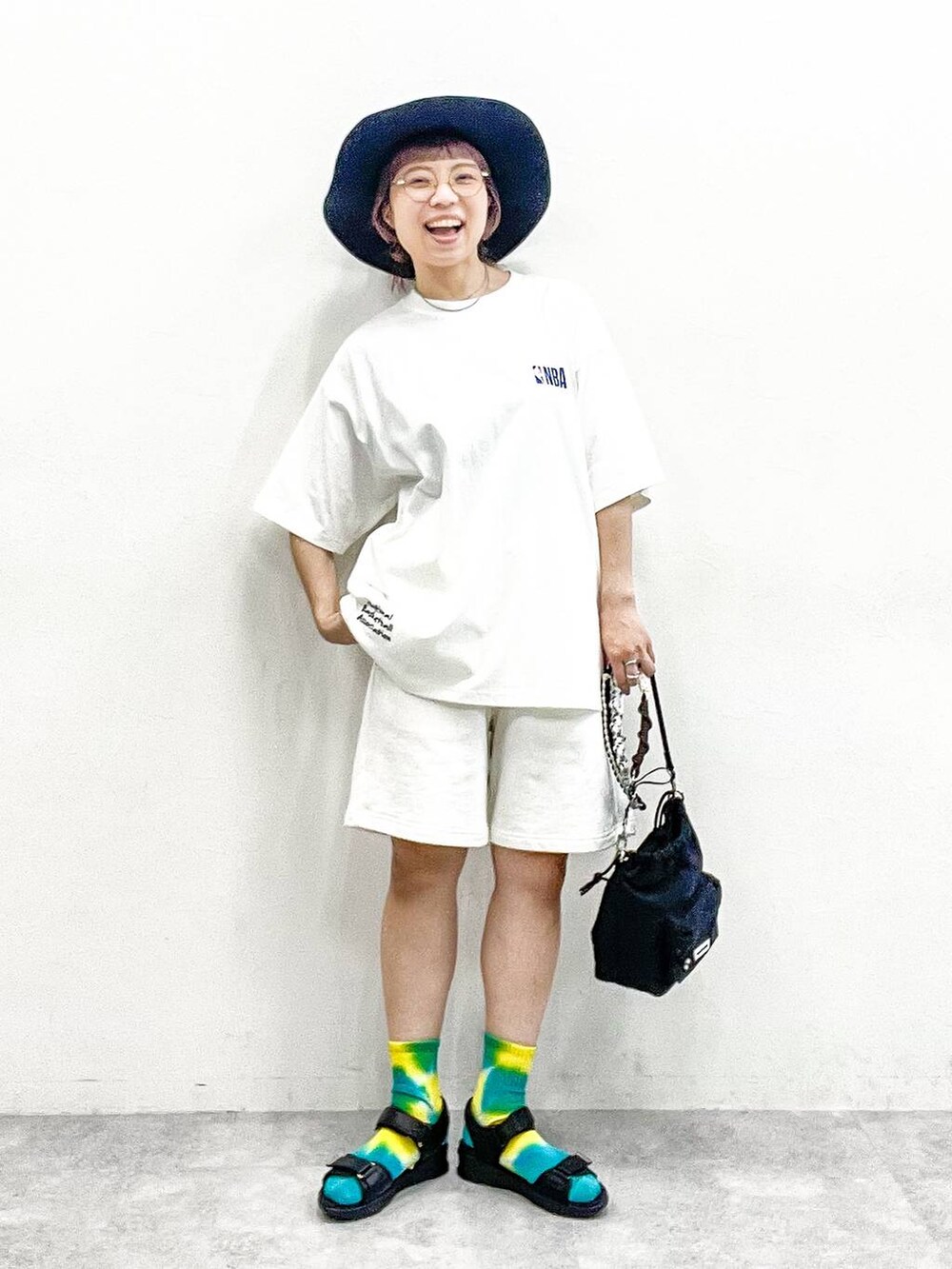 ブラック系のサンダル、ブラック系のショルダーバッグ、ホワイト系のTシャツ/カットソーを着用したレディースの夏コーディネートの3枚目の写真