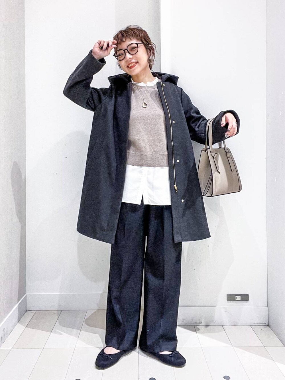 ベージュ系のショルダーバッグ、グレー系のノーカラーコート、ブラック系のその他パンツを着用したレディースの秋コーディネートの2枚目の写真