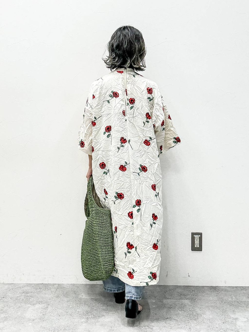 グリーン系のショルダーバッグ、ブラック系のサンダル、ブルー系のデニムパンツを着用したレディースの春コーディネートの4枚目の写真