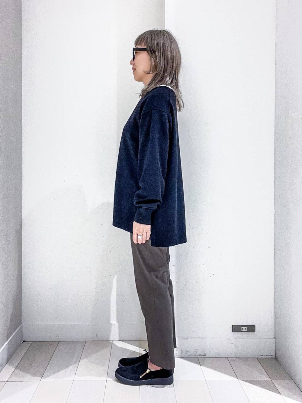 グレー系のチェスターコート、その他のTシャツ/カットソー、ブラック系のニット/セーターを着用したレディースの冬コーディネートの7枚目の写真