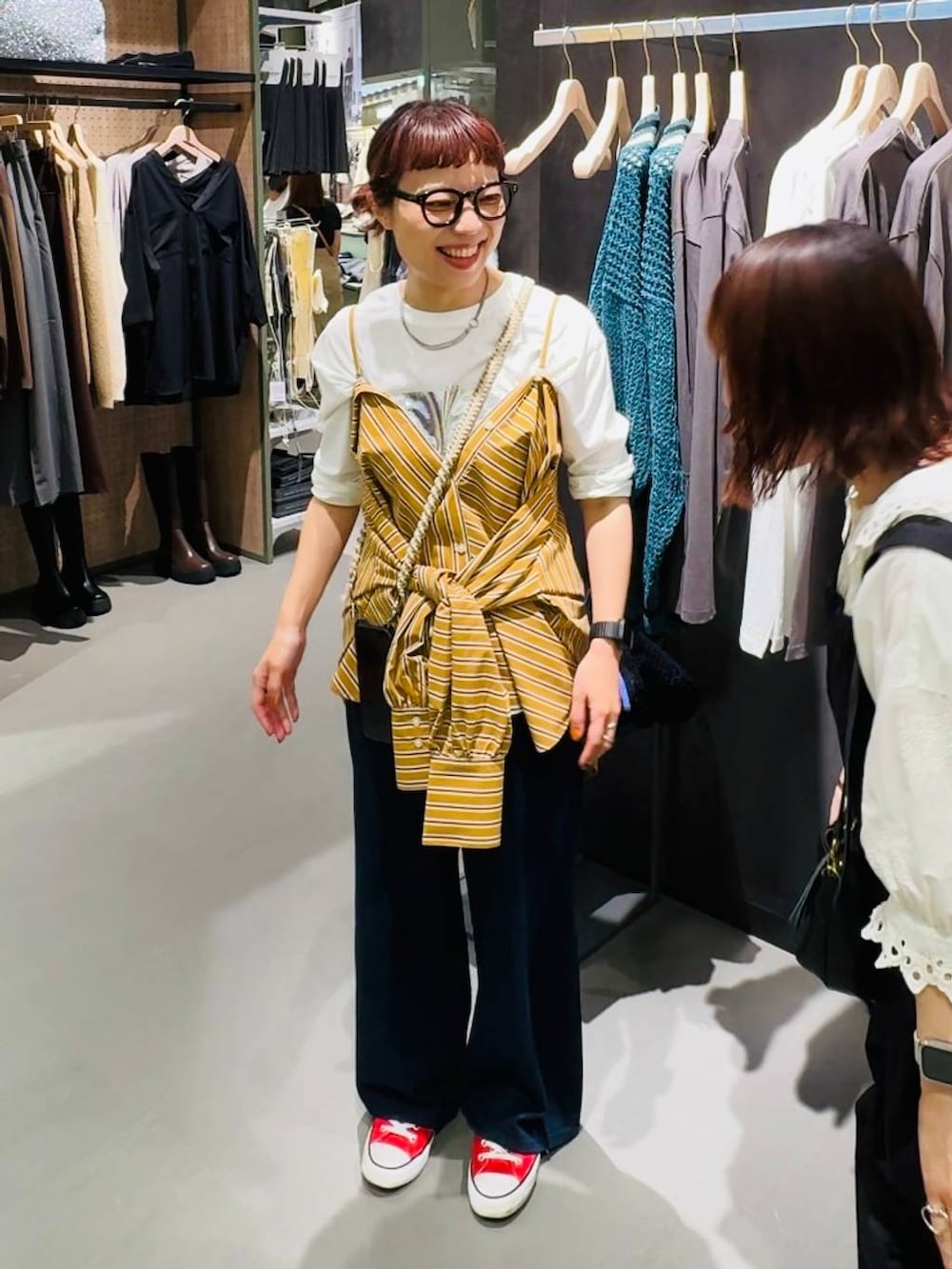 イエロー系のシャツ/ブラウス、ブラック系のバックパック/リュック、ホワイト系のTシャツ/カットソーを着用したレディースの秋コーディネートの2枚目の写真