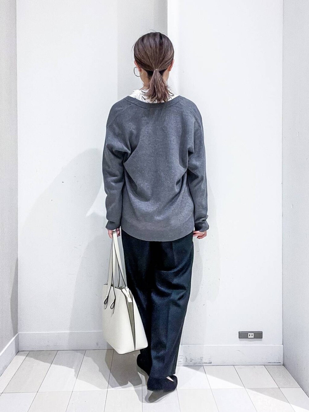 ブラック系のその他パンツ、ホワイト系のシャツ/ブラウス、グレー系のカーディガン/ボレロを着用したレディースの秋コーディネートの4枚目の写真