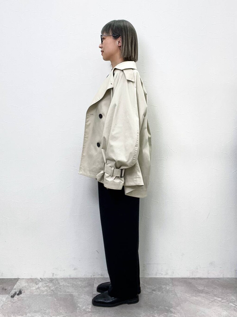 ブラック系のローファー、ベージュ系のトレンチコート、ブラック系のその他パンツを着用したレディースの春コーディネートの3枚目の写真