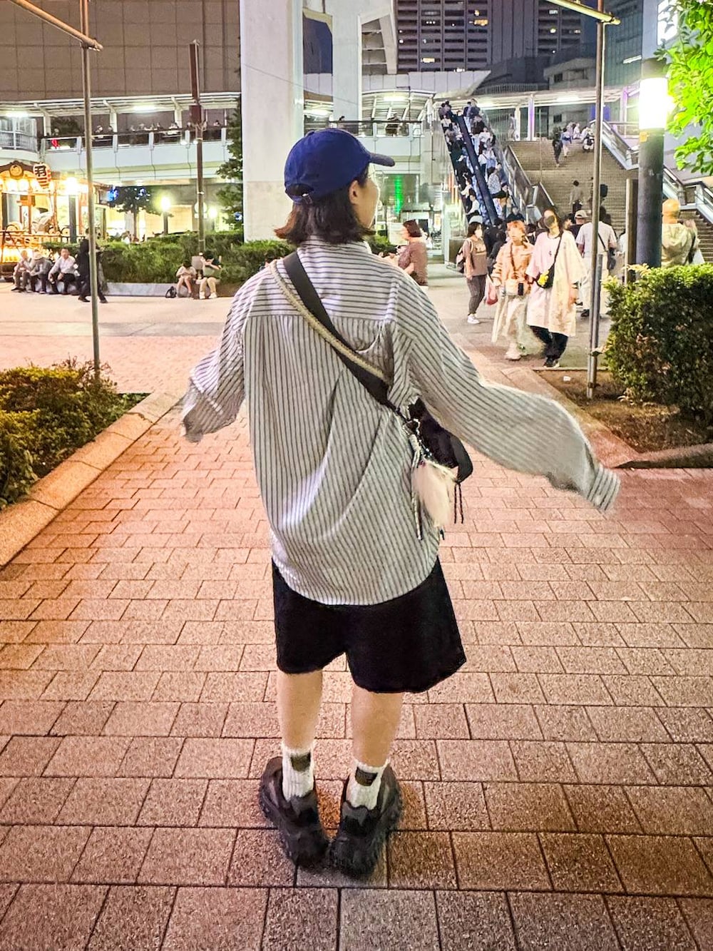 ブラック系のデニムパンツ、ベージュ系のシャツ/ブラウス、ブルー系のキャップを着用したレディースの秋コーディネートの4枚目の写真