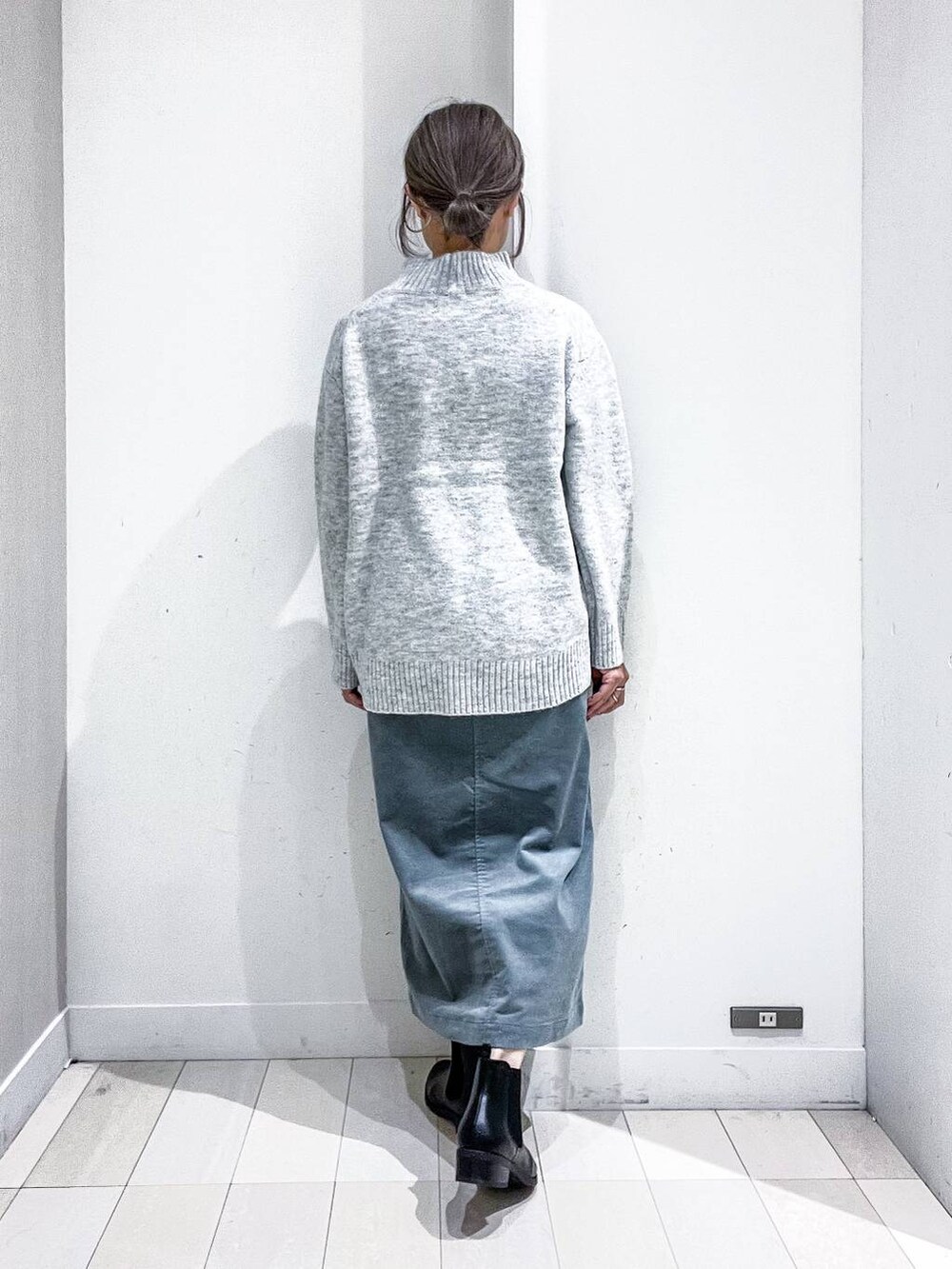 ブラック系のショルダーバッグ、ブラック系のダウンジャケット/コート、グリーン系のスカートを着用したレディースの冬コーディネートの8枚目の写真