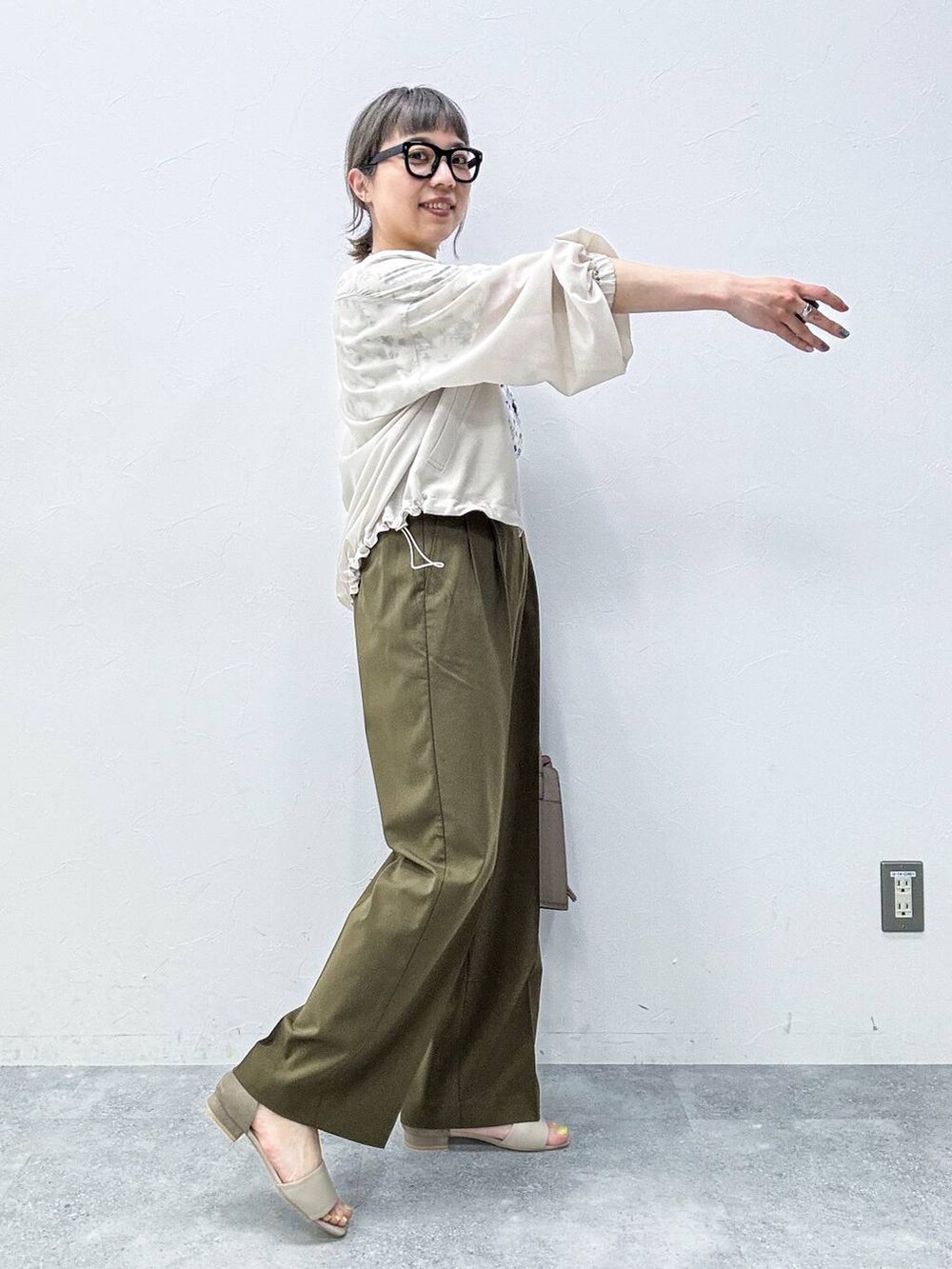 ベージュ系のショルダーバッグ、ベージュ系のサンダル、ホワイト系のシャツ/ブラウスを着用したレディースの春コーディネートの5枚目の写真