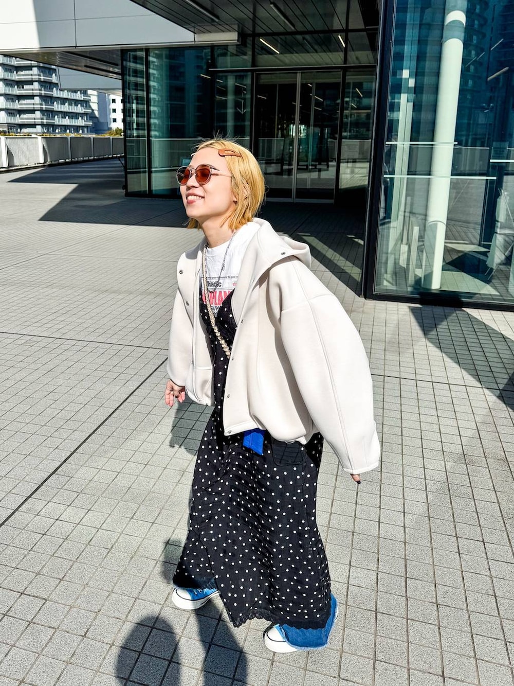 ホワイト系のブルゾン、ブラック系のワンピースを着用したレディースの冬コーディネートの3枚目の写真