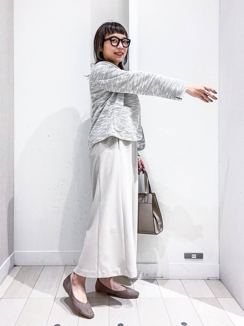 ベージュ系のショルダーバッグ、ホワイト系のTシャツ/カットソー、ベージュ系のパンプスを着用したレディースの秋コーディネートの5枚目の写真