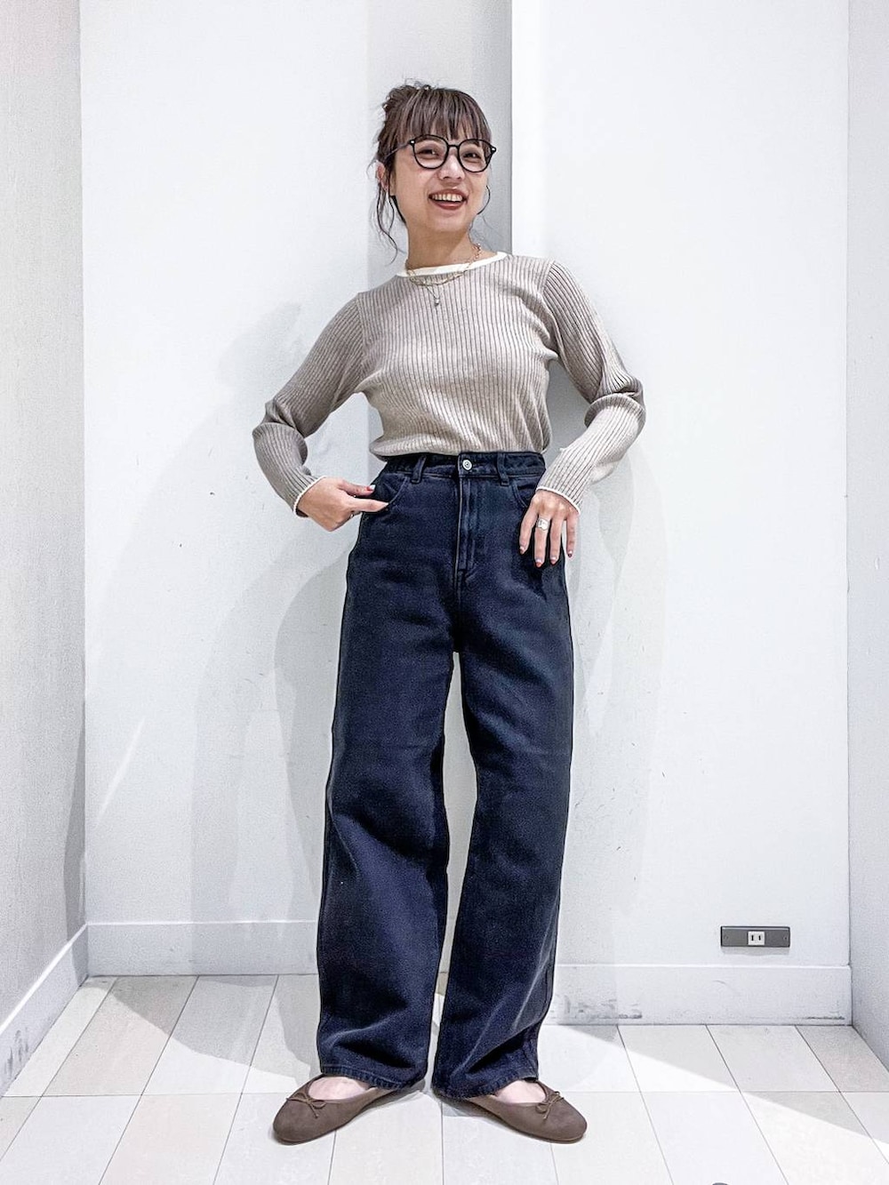 ベージュ系のニット/セーター、ブラック系のデニムパンツ、ベージュ系のトートバッグを着用したレディースの秋コーディネートの6枚目の写真