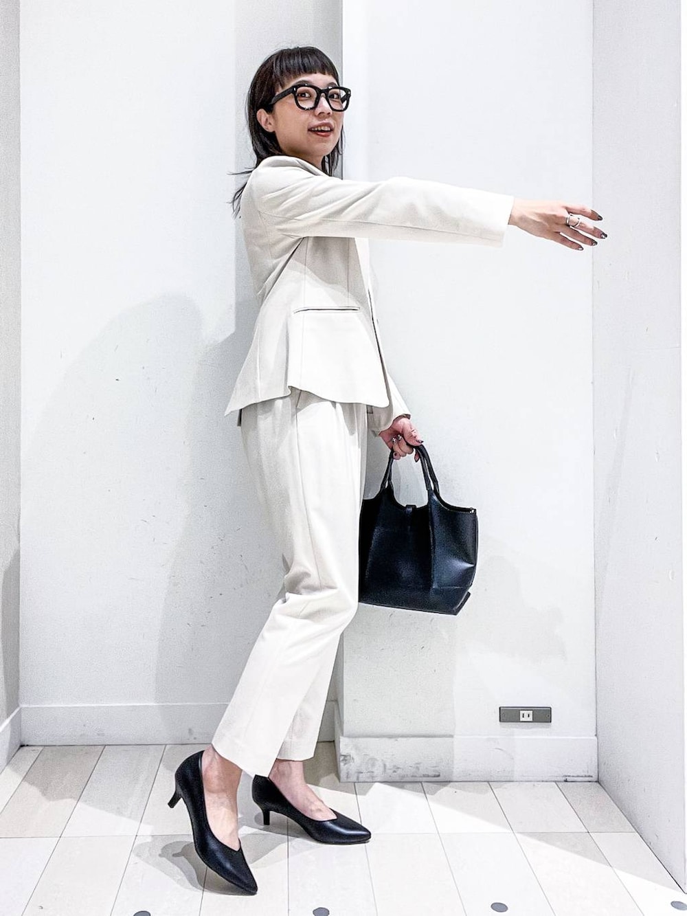 ブラック系のパンプス、ホワイト系のスーツジャケット、ホワイト系のシャツ/ブラウスを着用したレディースの冬コーディネートの5枚目の写真