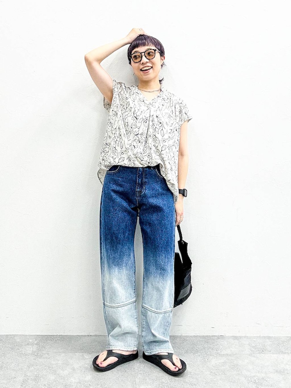 ブラック系のショルダーバッグ、ブルー系のデニムパンツ、ブラック系のサンダルを着用したレディースの夏コーディネートの7枚目の写真
