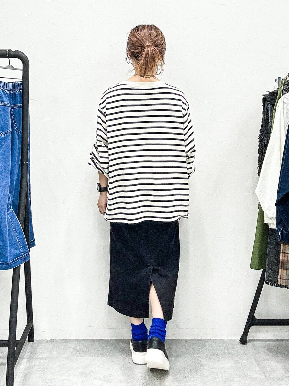 ブラック系のスカート、ブラック系のスリッポン、グレー系のTシャツ/カットソーを着用したレディースの秋コーディネートの4枚目の写真