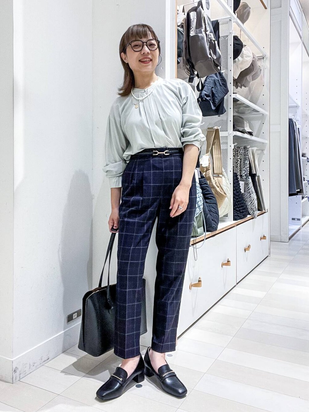 ブルー系のその他パンツ、グリーン系のシャツ/ブラウス、ブラック系のトートバッグを着用したレディースの夏コーディネートの2枚目の写真