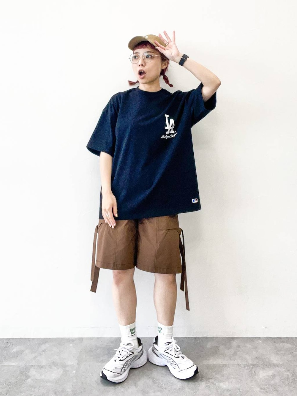 ブラウン系のカーゴパンツ、ブラック系のTシャツ/カットソー、ベージュ系のキャップを着用したレディースの夏コーディネートの2枚目の写真