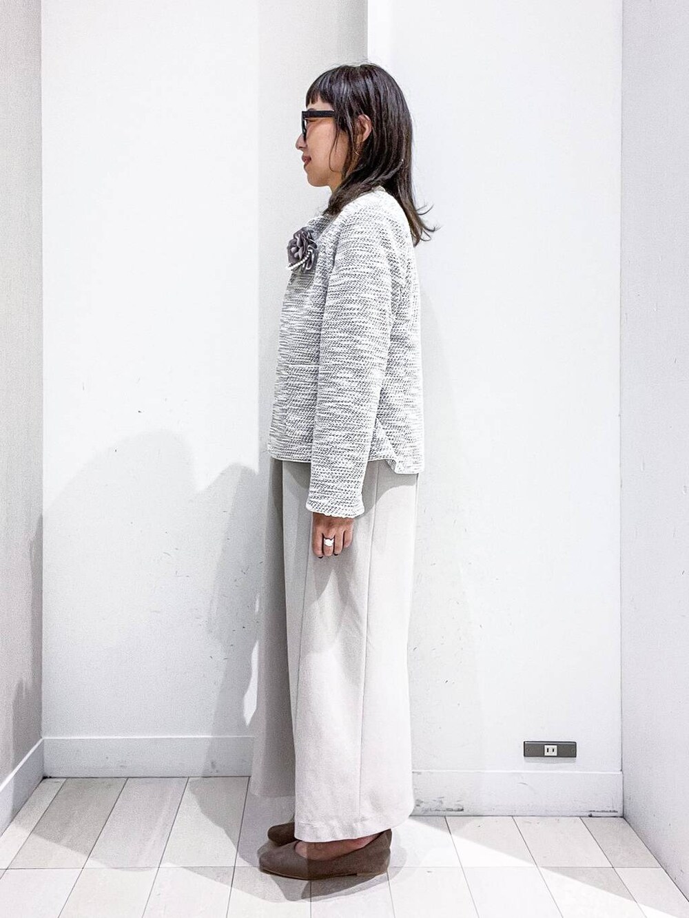 ベージュ系のショルダーバッグ、ホワイト系のTシャツ/カットソー、ベージュ系のパンプスを着用したレディースの秋コーディネートの3枚目の写真