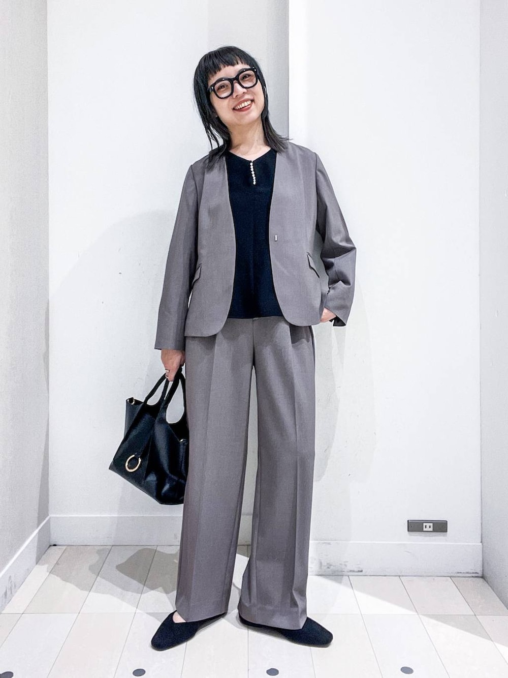 ブラック系のパンプス、ブラウン系のスーツジャケット、ブラック系のシャツ/ブラウスを着用したレディースの秋コーディネートの2枚目の写真