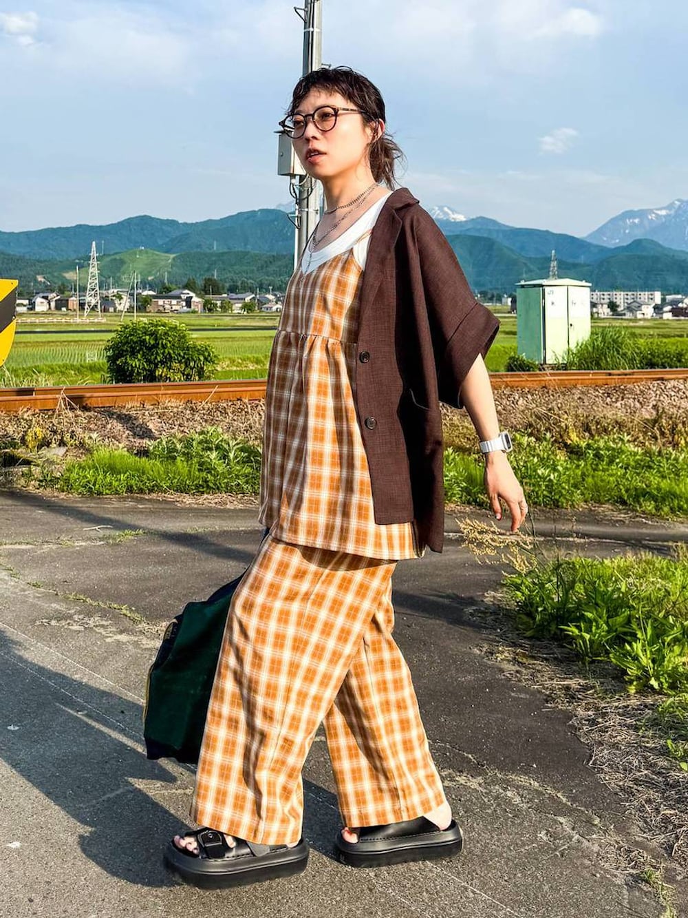 ホワイト系のタンクトップ、ブラック系のサンダル、ブラウン系のテーラードジャケットを着用したレディースの夏コーディネートの4枚目の写真