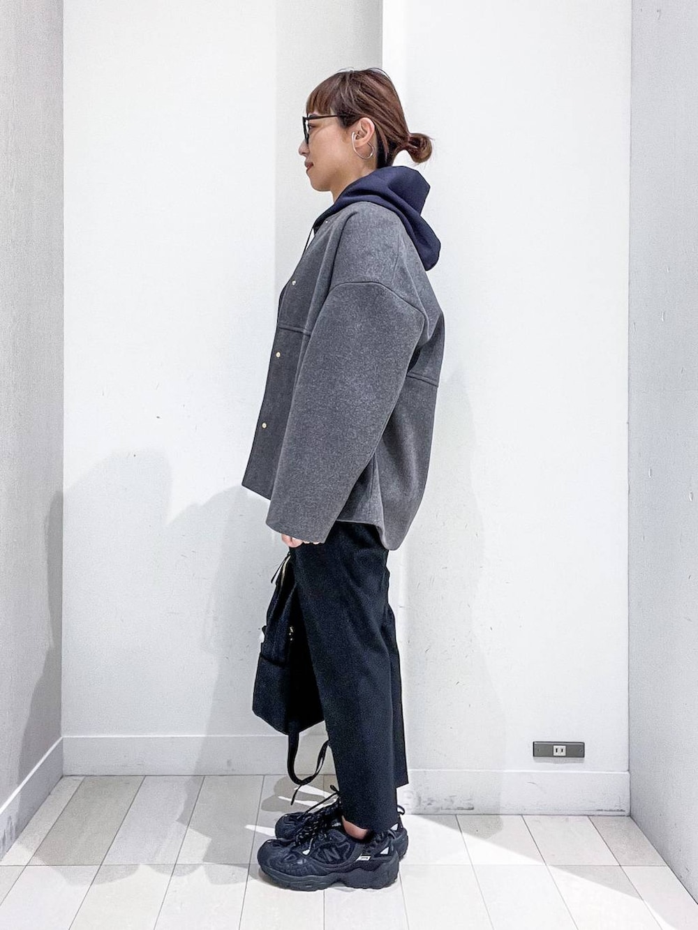 ブラック系のバックパック/リュック、グレー系のノーカラーコート、ブラック系のその他パンツを着用したレディースの秋コーディネートの3枚目の写真