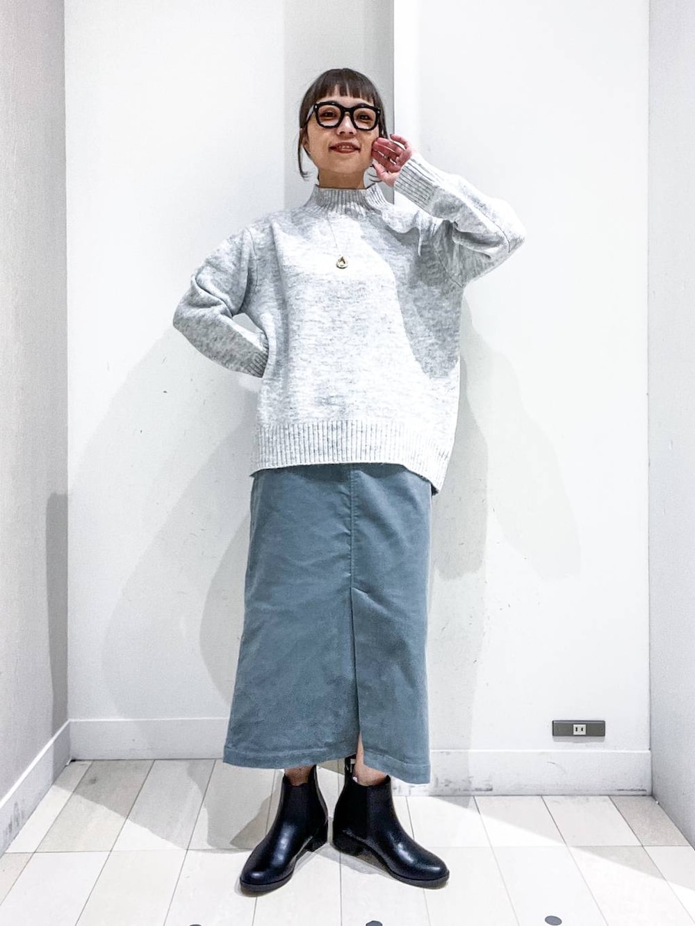 ブラック系のショルダーバッグ、ブラック系のダウンジャケット/コート、グリーン系のスカートを着用したレディースの冬コーディネートの6枚目の写真