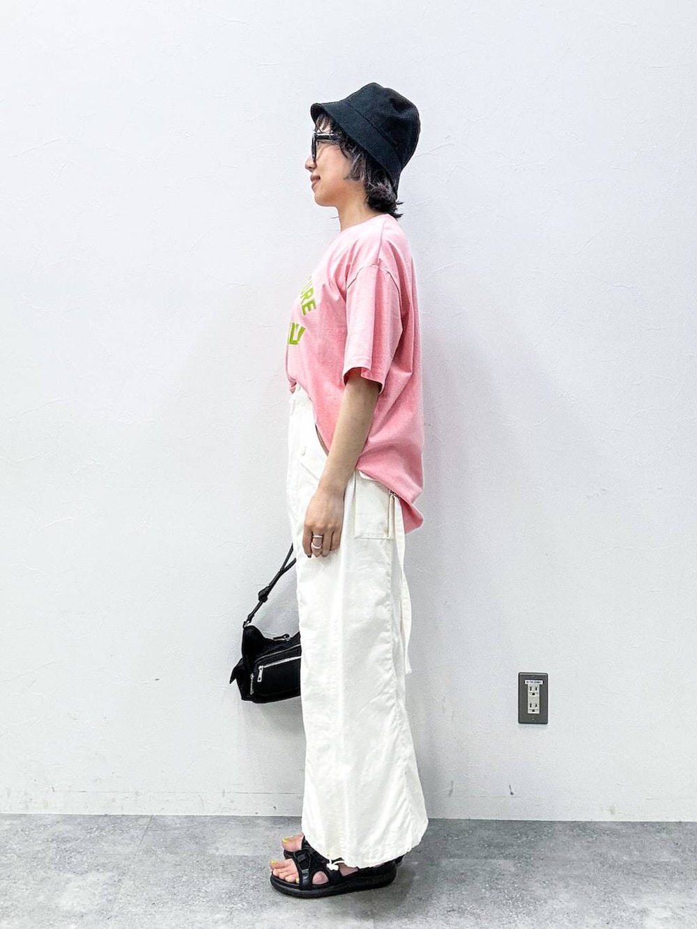 ホワイト系のスカート、ブラック系のサンダル、ピンク系のTシャツ/カットソーを着用したレディースの春コーディネートの3枚目の写真