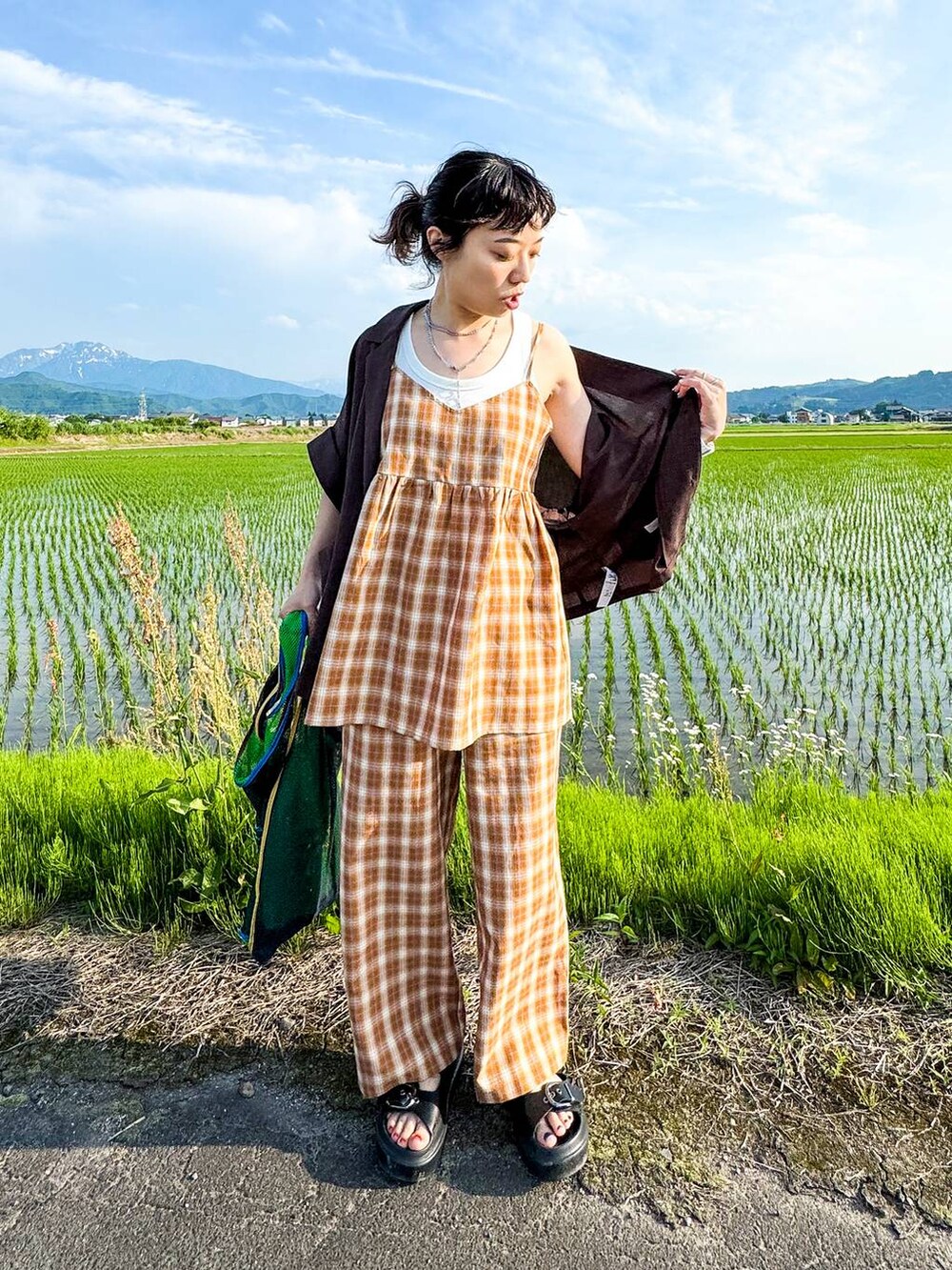 ホワイト系のタンクトップ、ブラック系のサンダル、ブラウン系のテーラードジャケットを着用したレディースの夏コーディネートの7枚目の写真