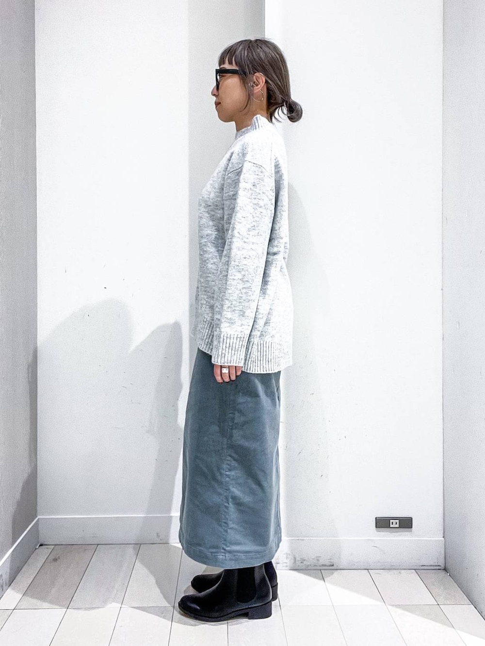 ブラック系のショルダーバッグ、ブラック系のダウンジャケット/コート、グリーン系のスカートを着用したレディースの冬コーディネートの7枚目の写真