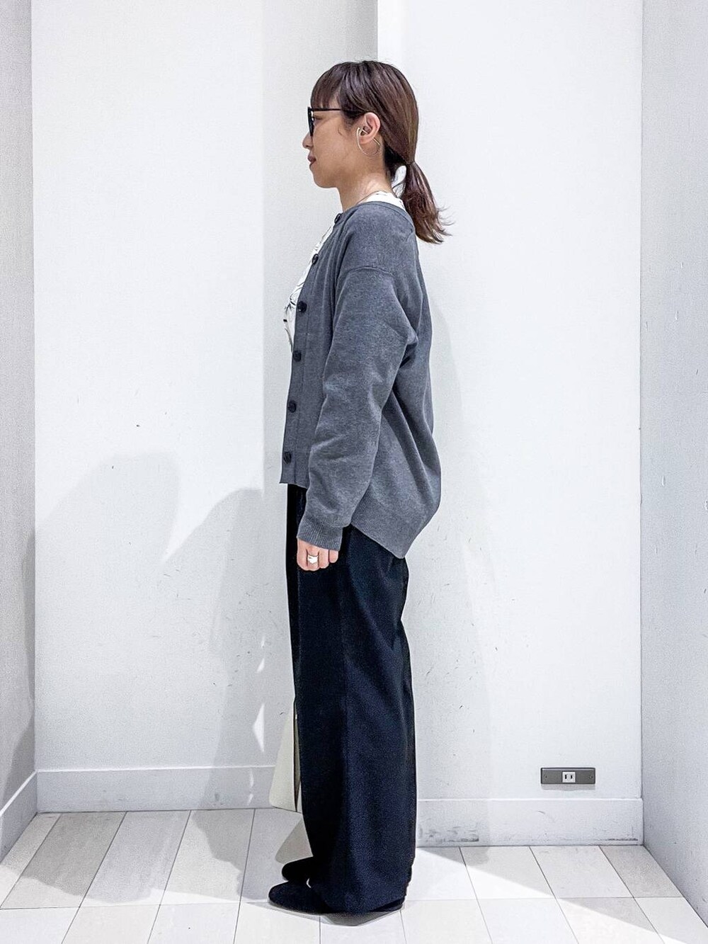 ブラック系のその他パンツ、ホワイト系のシャツ/ブラウス、グレー系のカーディガン/ボレロを着用したレディースの秋コーディネートの3枚目の写真