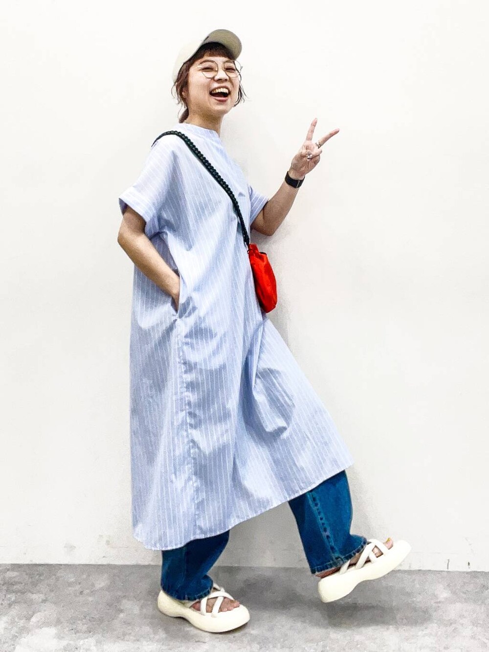 ホワイト系のサンダル、オレンジ系のショルダーバッグ、ブルー系のデニムパンツを着用したレディースの夏コーディネートの6枚目の写真