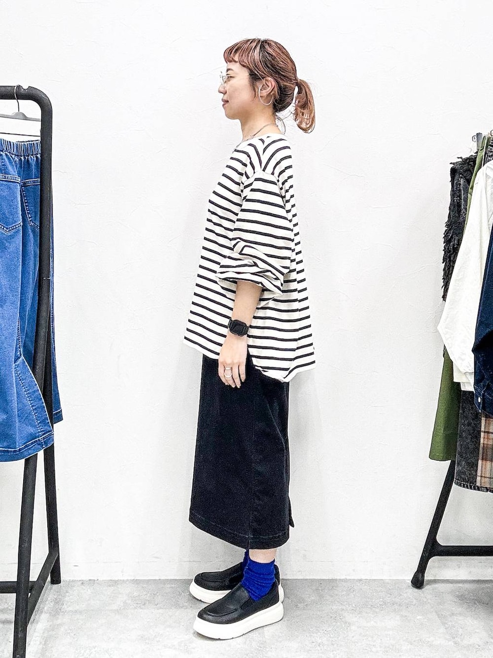 ブラック系のスカート、ブラック系のスリッポン、グレー系のTシャツ/カットソーを着用したレディースの秋コーディネートの3枚目の写真