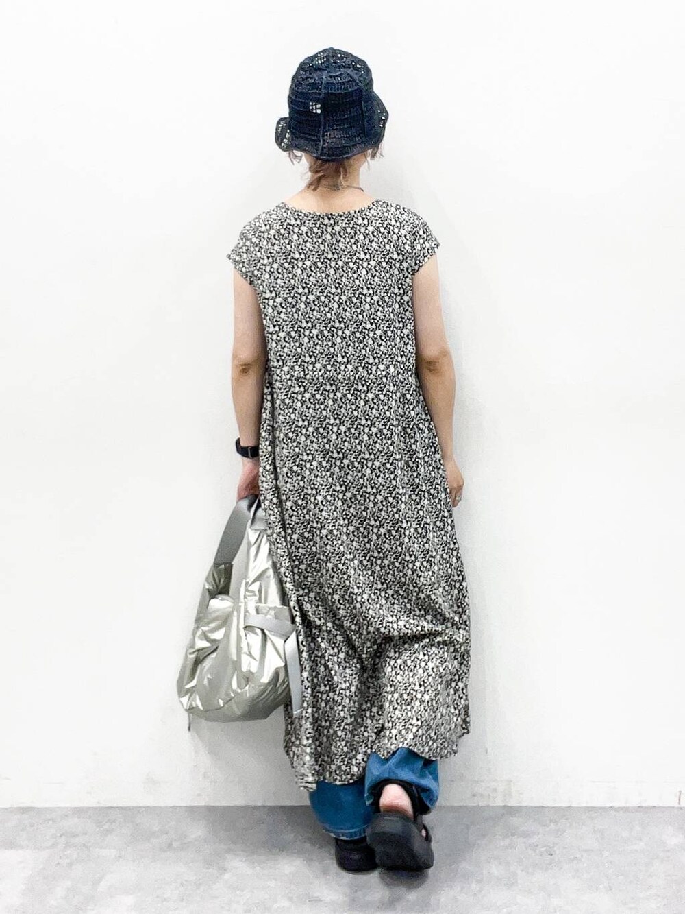 シルバー系のショルダーバッグ、ブルー系のデニムパンツ、ブラック系のサンダルを着用したレディースの夏コーディネートの4枚目の写真