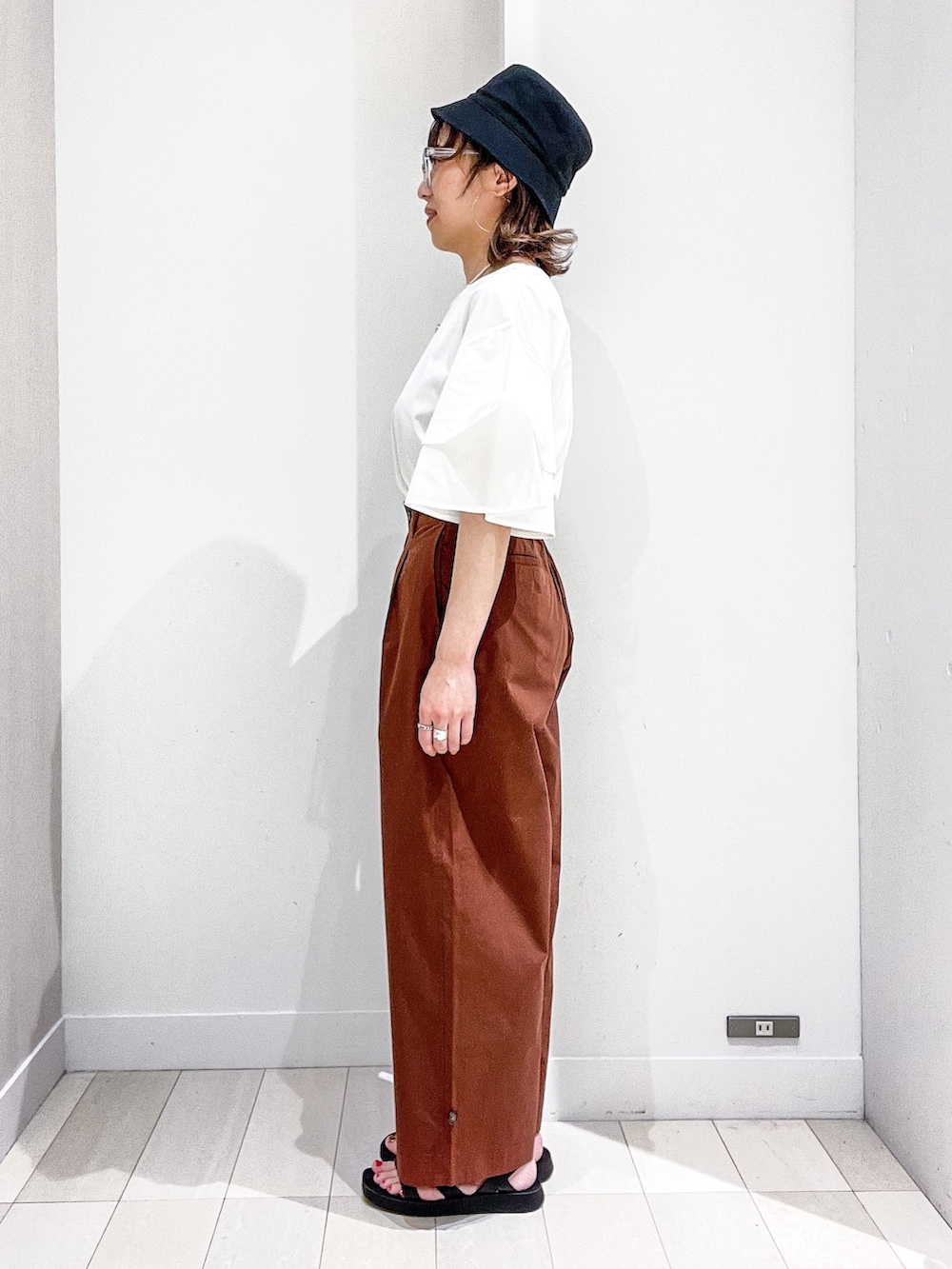 ホワイト系のTシャツ/カットソー、ブラウン系のその他パンツ、ブラック系のバッグを着用したレディースの夏コーディネートの3枚目の写真