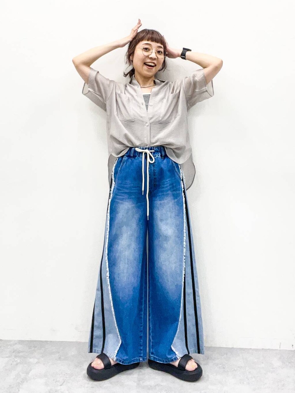 グレー系のシャツ/ブラウス、グレー系のタンクトップ、ブルー系のデニムパンツを着用したレディースの夏コーディネートの7枚目の写真