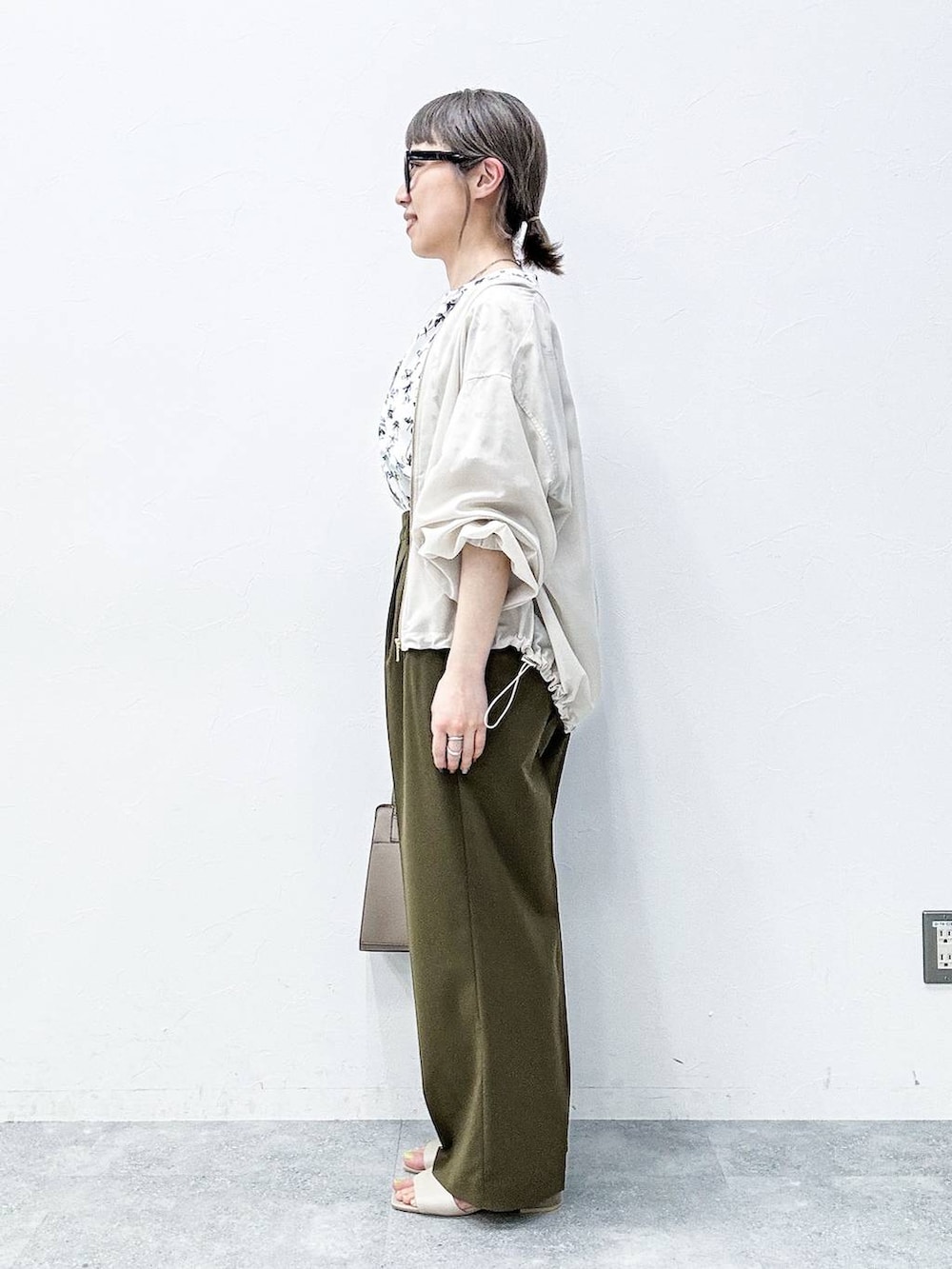 ベージュ系のショルダーバッグ、ベージュ系のサンダル、ホワイト系のシャツ/ブラウスを着用したレディースの春コーディネートの3枚目の写真