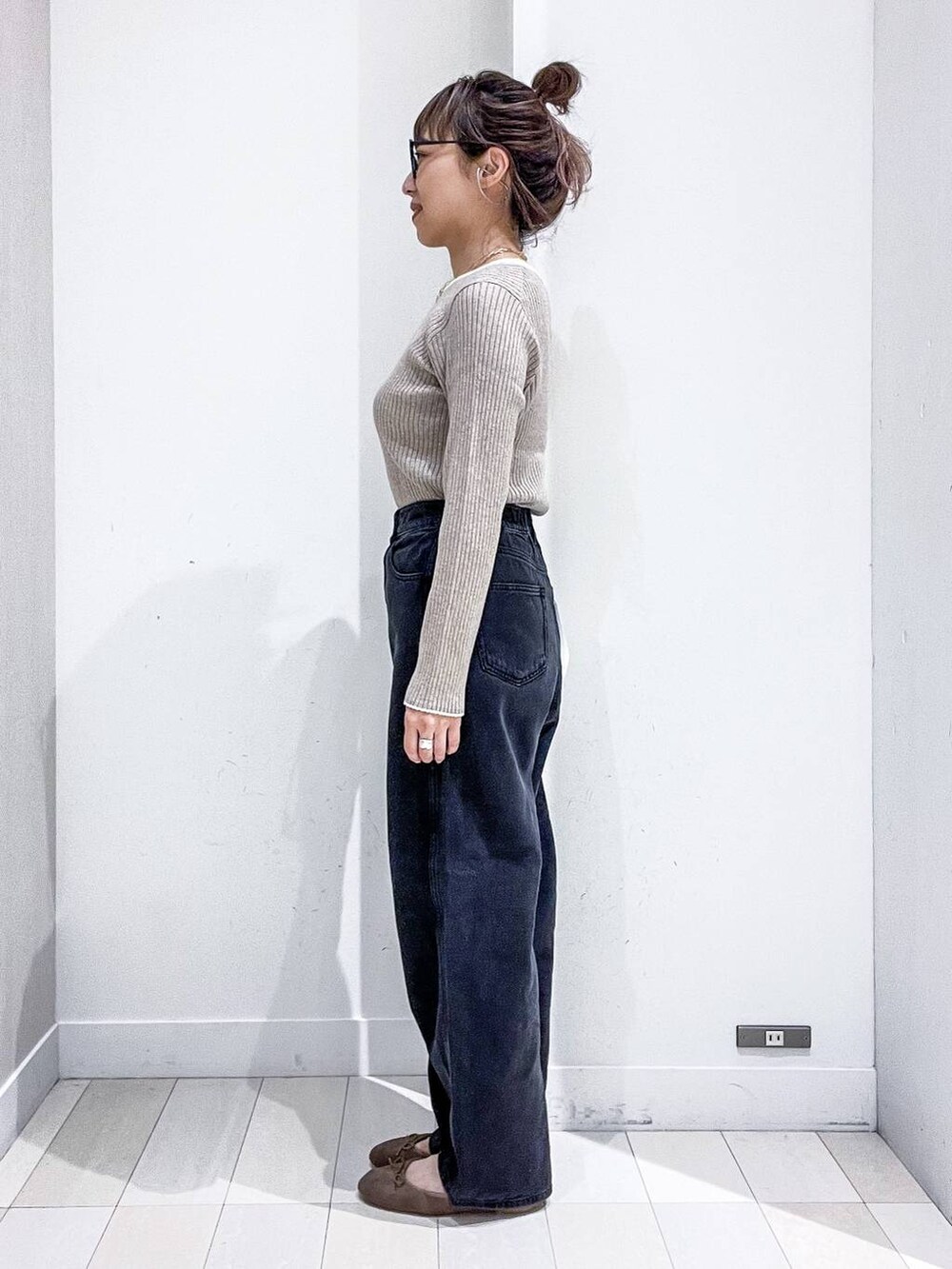 ベージュ系のニット/セーター、ブラック系のデニムパンツ、ベージュ系のトートバッグを着用したレディースの秋コーディネートの7枚目の写真