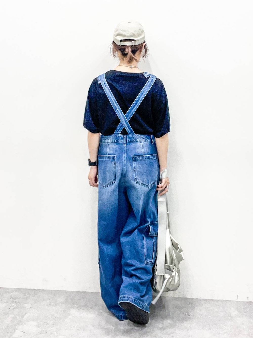 シルバー系のショルダーバッグ、ブラック系のTシャツ/カットソー、ブルー系のサロペット/オーバーオールを着用したレディースの夏コーディネートの4枚目の写真