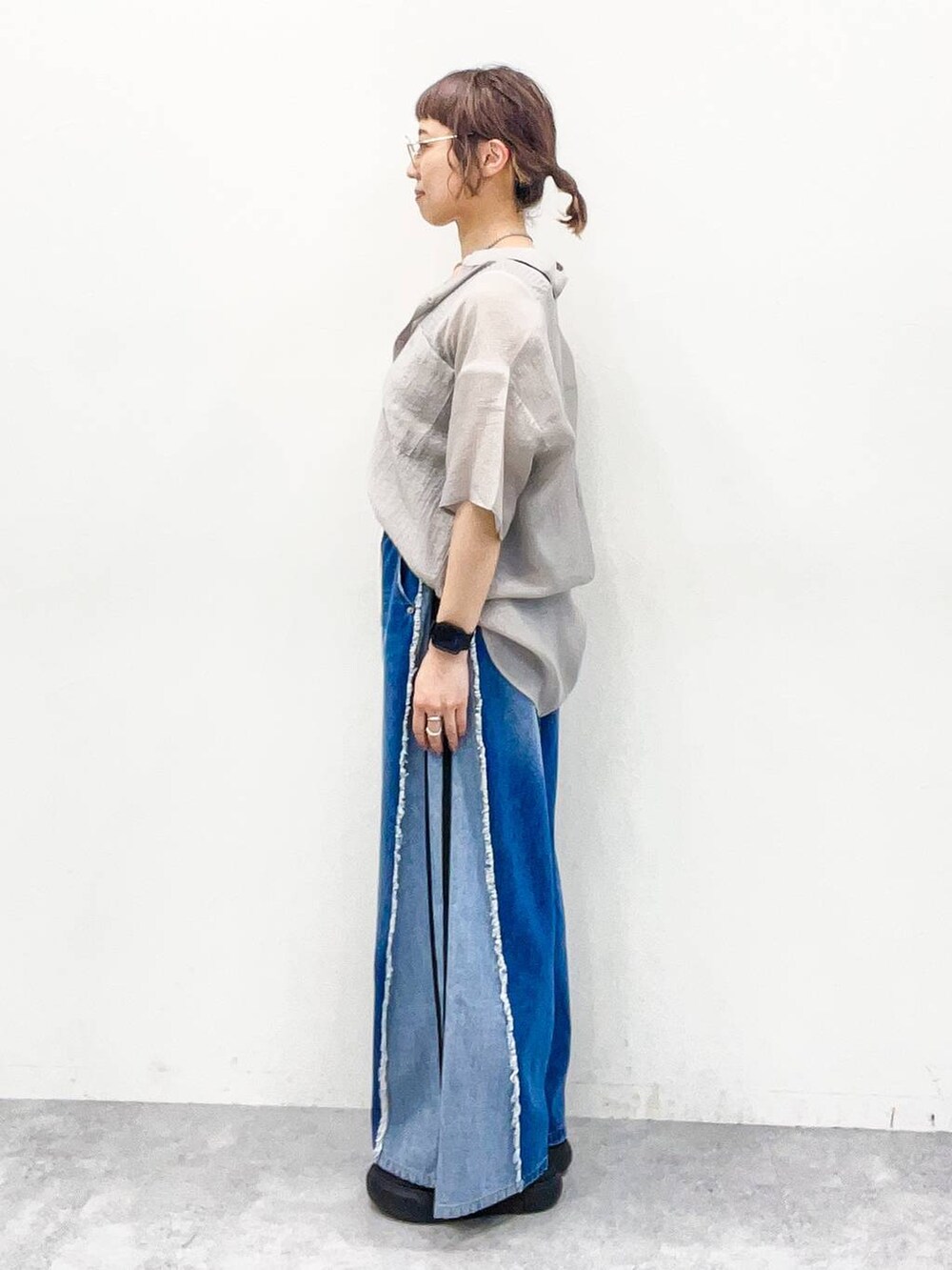 グレー系のシャツ/ブラウス、グレー系のタンクトップ、ブルー系のデニムパンツを着用したレディースの夏コーディネートの3枚目の写真