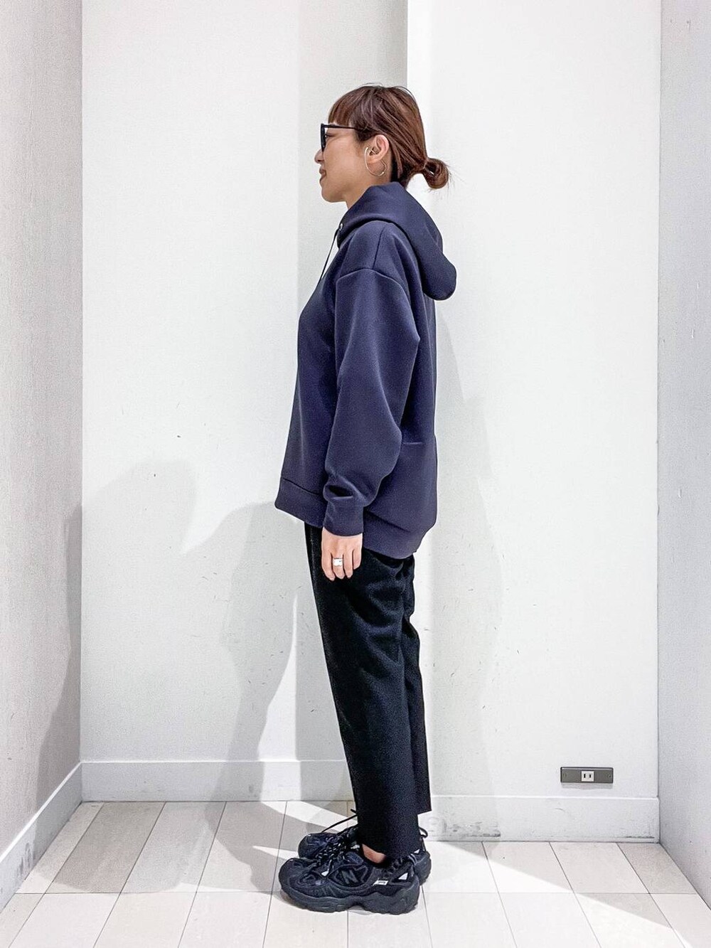 ブラック系のバックパック/リュック、グレー系のノーカラーコート、ブラック系のその他パンツを着用したレディースの秋コーディネートの7枚目の写真