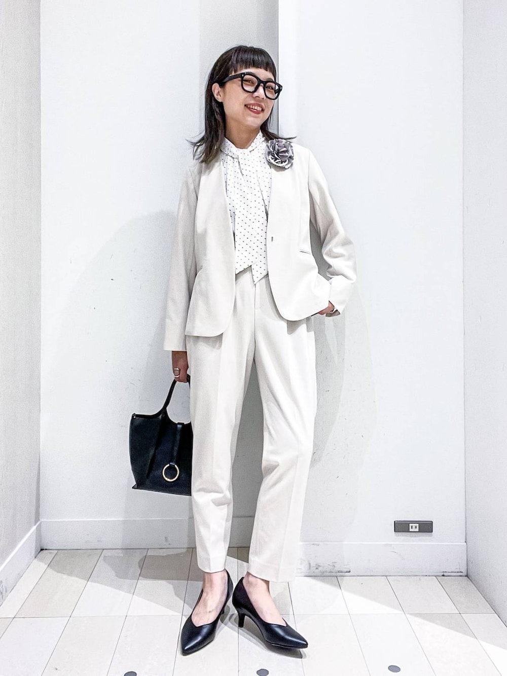 ブラック系のパンプス、ホワイト系のスーツジャケット、ホワイト系のシャツ/ブラウスを着用したレディースの冬コーディネートの2枚目の写真